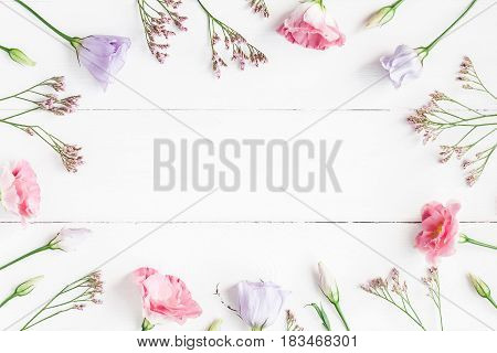 Flowers composition. Frame made of various flowers on white wooden background. Flat lay top view
