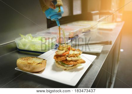 Chef Adding Sauce On Burger. Preparing Burger.