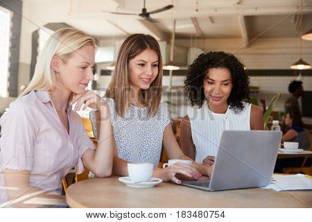 Three Businesswomen Meet In Coffee Shop Shot Through Window