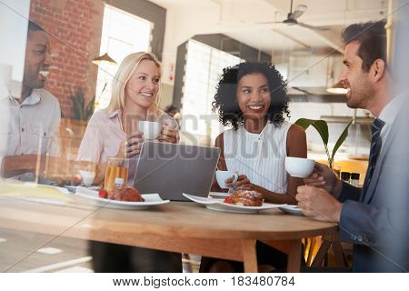 Businesspeople Meeting In Coffee Shop Shot Through Window