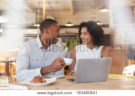 Two Businesspeople Meet In Coffee Shop Shot Through Window