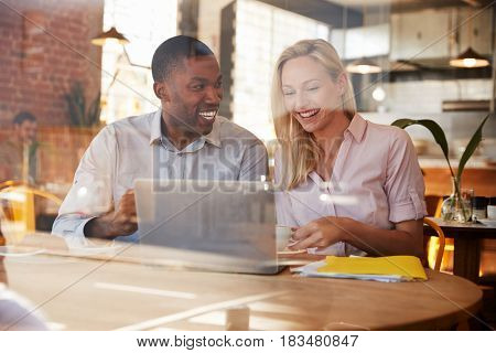 Two Businesspeople Meet In Coffee Shop Shot Through Window