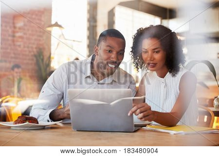 Two Businesspeople Meet In Coffee Shop Shot Through Window