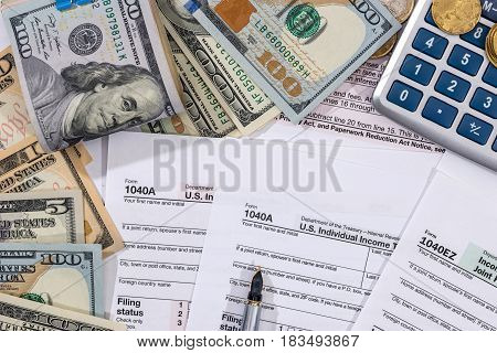 Filing taxes form money calculator and pen.