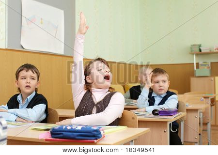 Scolaro dietro scrivanie a scuola