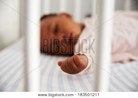 Close Up Of Baby Girl Sleeping In Nursery Cot