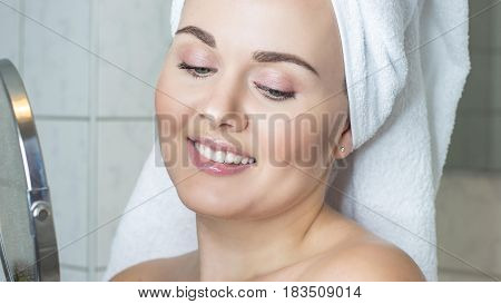Happy young woman with a white towel on her head. The girl after a shower in a towel.