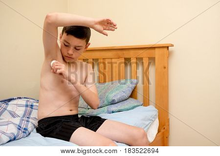Young caucasian teenage boy using antiperspirant in the morning