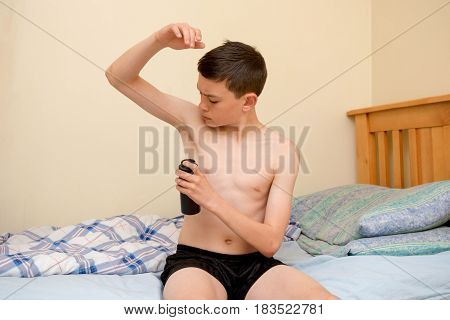 Young caucasian teenage boy using antiperspirant in the morning
