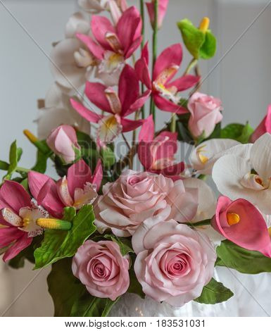 Cake with decorative white, green and pink sugar or pastry mastic flowers