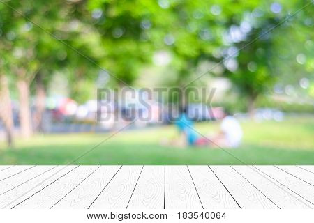 Empty white table perspective wood over blur park with people background for product display montage background