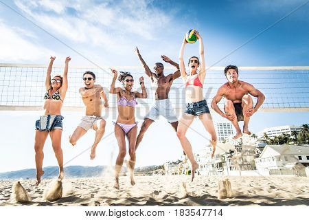 Group of friends playing beach volley - Multi-ethic group of people having fun on the beach