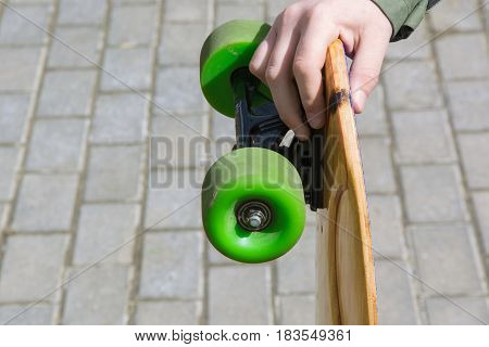 Teen hold longboard in hand. Close up.