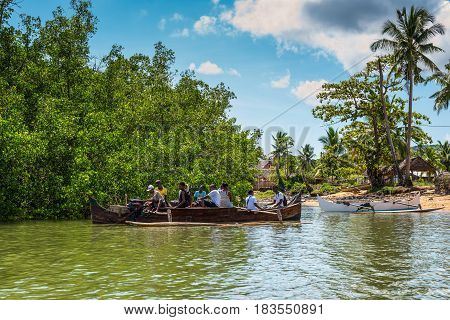 Ambatozavavy Nosy Be Madagascar - December 19 2015: Locals on the traditional wood pirogue with outrigger on the shore of the fishing village on the Nosy Be island Madagascar.