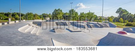 Empty concrete skatepark. Beautiful weather and blue sky.
