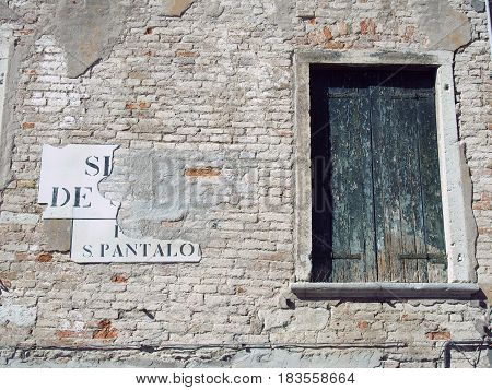 shuttered window on an exterior old brick wall in venice