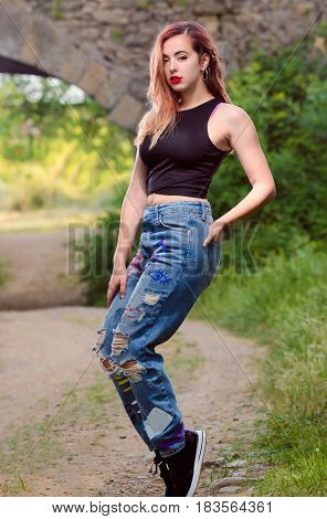 Beautiful fashion woman posing on toes in the field