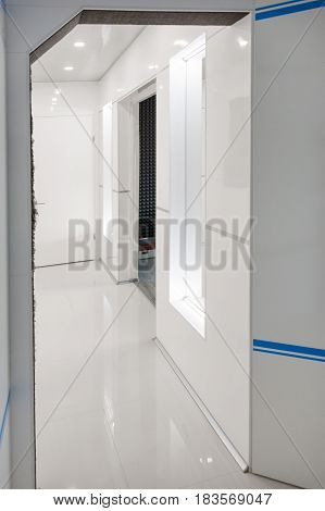Modern home hallway interior. White plactic panels and tiles. Futuristic interior concept design. Space ship at home