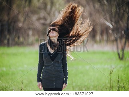 Girl with long flying hair on a nature background.