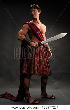 The tough highlander is showing off his sword.