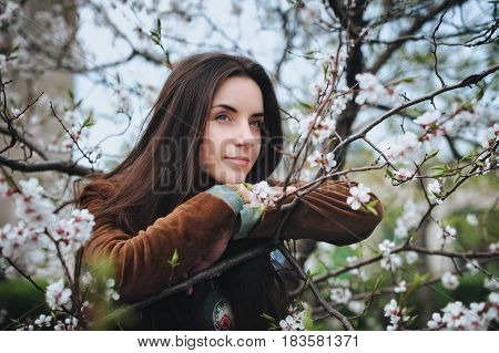 Young beautiful girl near a blossom apricot tree. Spring dreams.
