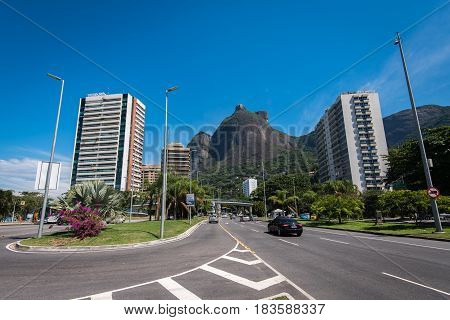 Rio de Janeiro, Brazil - April 6, 2017: Main avenue crossing Sao Conrado has apartment buildings built along it, and is surrounded by mountains.