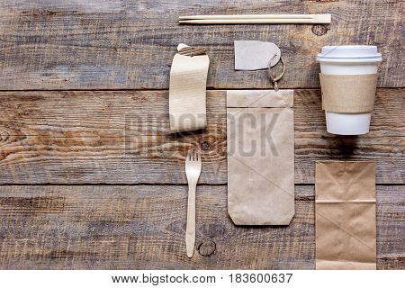 food delivery workdesk with paper bags and flatware on restourant wooden table background top view mock-up