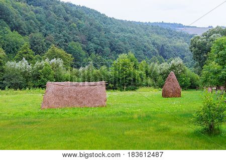 Haystack Near Orchard On Hillside. Agricultural Field In Mountain Area. Beautiful