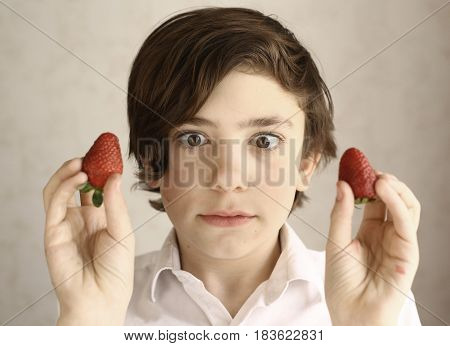 Preteen Boy Acting Grimacing With Two Strawberries