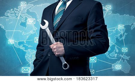 Businessman holding tool with global map graphic on the background
