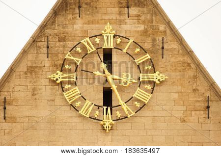 Huge golden clock on the facade of a building. Architectural detail