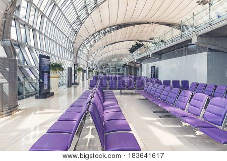 BANGKOK THAILAND - MARCH 7 2017 Interior of a modern airport a number of seats in the glassed-in room walkway for passengers boarding walkway in airport.
