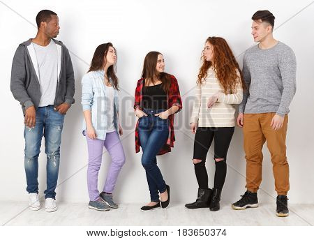 Group of people. Diverse students in casual outfits standing in line on white studio background