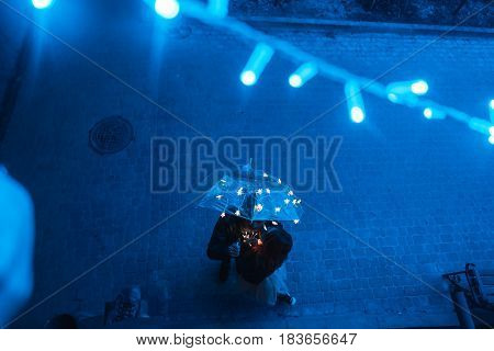 Guy and girl are looking at the camera on the night street
