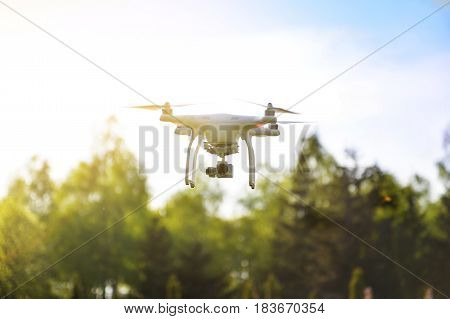 Quadrocopter flies in the air at sunset. Launching a quadrocopter in the park
