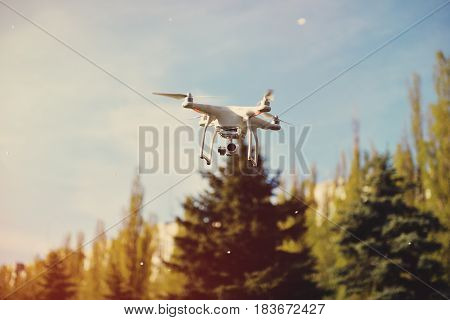 Quadrocopter flies in the air at sunset. Launching a quadrocopter in the park