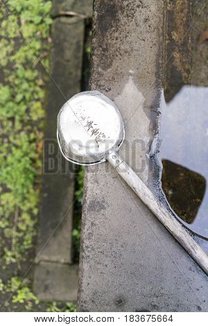 Stone water basin and old ladle at Shinto shrine in Tokyo Japan