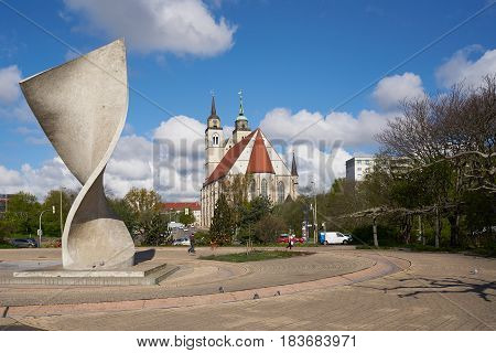 MAGDEBURG, GERMANY - APRIL 19, 2017: Flag monument and St. Johannis-Church on the banks of the river Elbe in Magdeburg. The St. Johonnis-Church in Magdeburg is a former church building and has been used since 1999 for concerts and events.