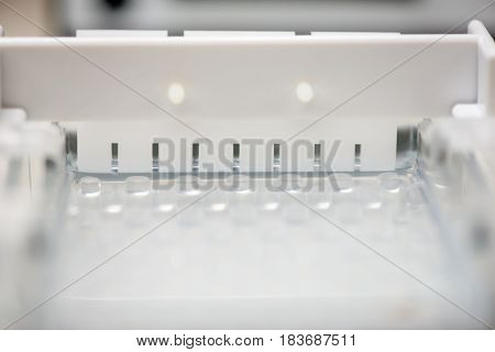 Close-up detail of a electrophoresis comb in an mold filled with agarose gel undergoing solidification. Molecular genetics and medical diagnosis technology concept.