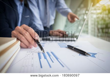 Teamwork process Businessmen hands pointing at laptop and document during explanation of new plan project data at meeting.
