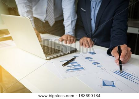 Teamwork process Young businessmen hands pointing at document and laptop during explanation of new plan project data at meeting.