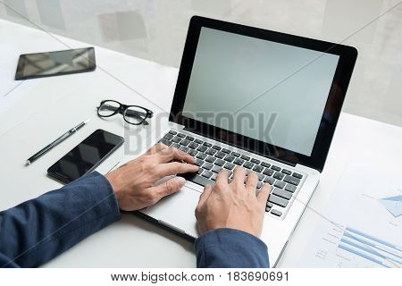 Professional businessman working at his office with laptop and smartphone work process concept.