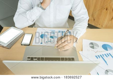 Business man working at office with laptoptablet and documents on his desk.