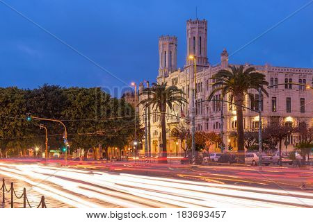 Cagliari, Sardinia - January 2 of 2016, Italy: Town Hall, Municipio di Cagliari also known as Palazzo Vivanet, evening view of The Street of Rome with traffic light trails