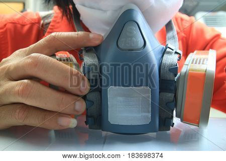 Multi-purpose respirator half mask for toxic gas protection.The man prepare to wear Multi-purpose respirator half mask.