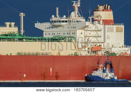 GAS CARRIER - Great ship and small tugboat in the sun