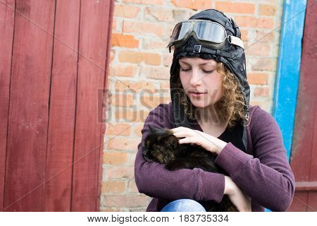 Portrait of a young girl in pilot hat and glasses with cat