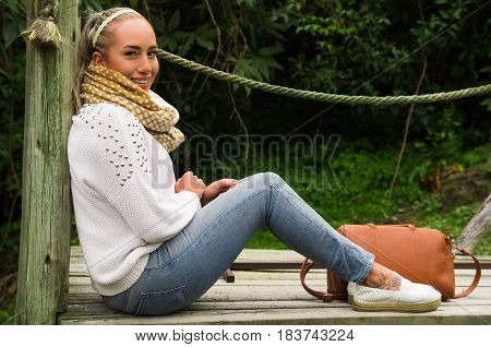 Beautiful young blond contemplative woman in a sitting enjoying nature