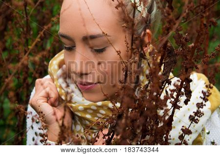 Close up shot of beautiful young latin girl behind some forest weeds