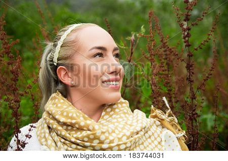 Close up portrait of smiling beautiful woman enjoying nature in a forest
